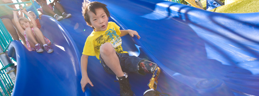 Child sliding down a Playmore accessible playground slide, Courtesy of Playmore Facebook Page