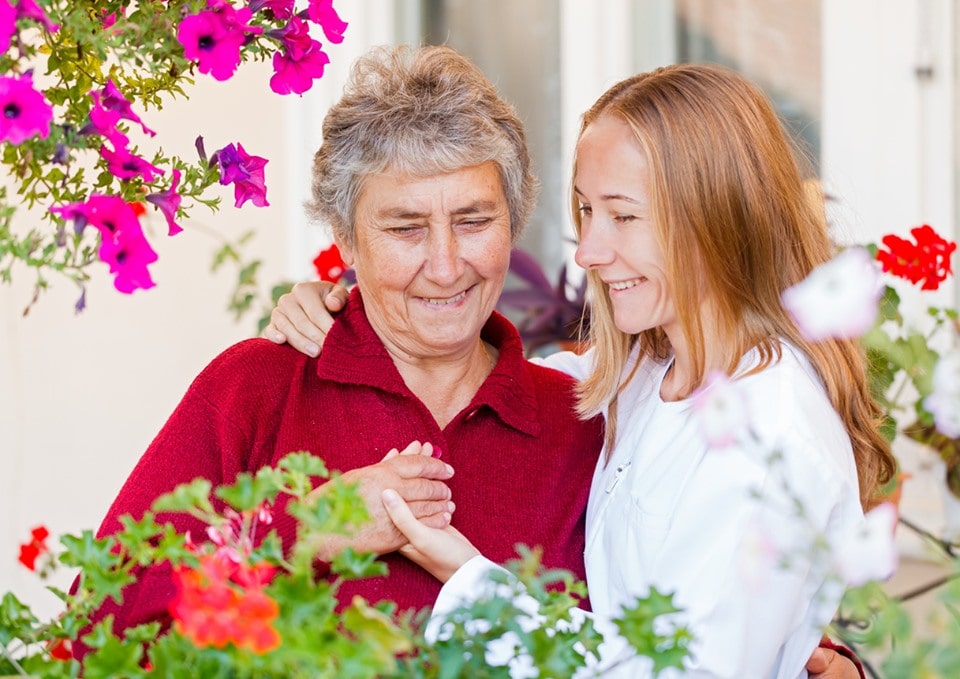 Senior woman with granddaughter surrounded by flowers