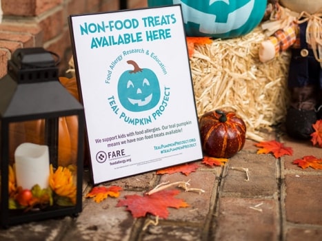 The Teal Pumpkin Project promotes food allergy awareness and an inclusive Halloween experience. Images shows framed FARE poster. 