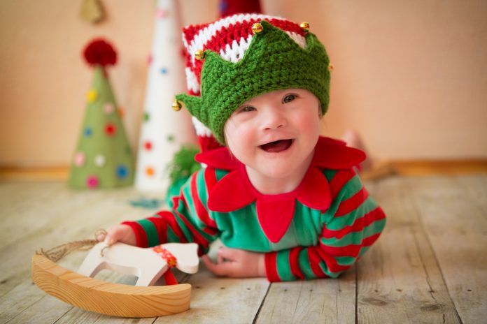 smiling baby with down syndrome dressed as elf