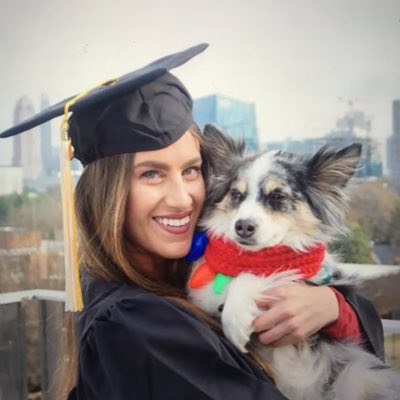 Ali Kight, founder of TINA Healthcare, dressed in graduation cap and gown and holding her dog