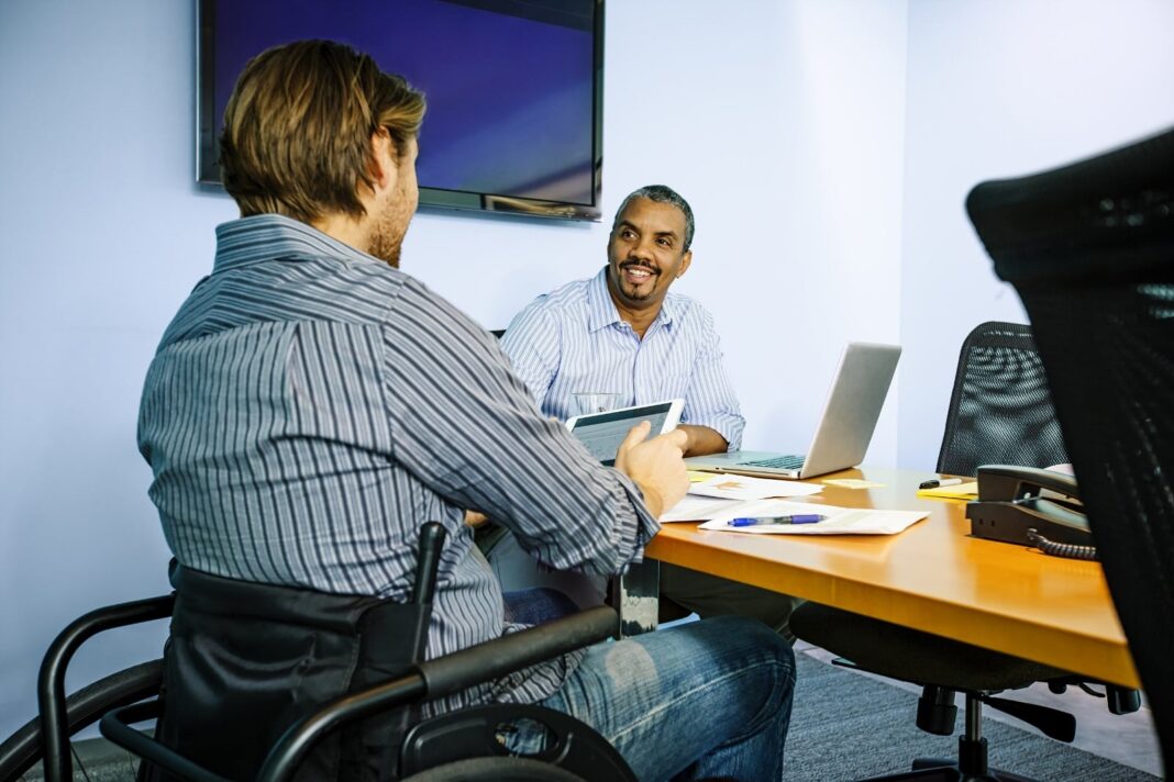inclusive workplace credit National Disability Institute two male employees collaborate in a inclusive workplace setting