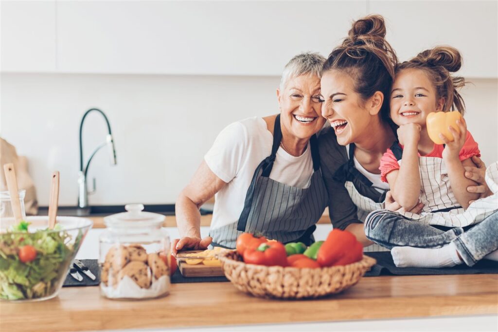 three generations of women cooking and laughing together