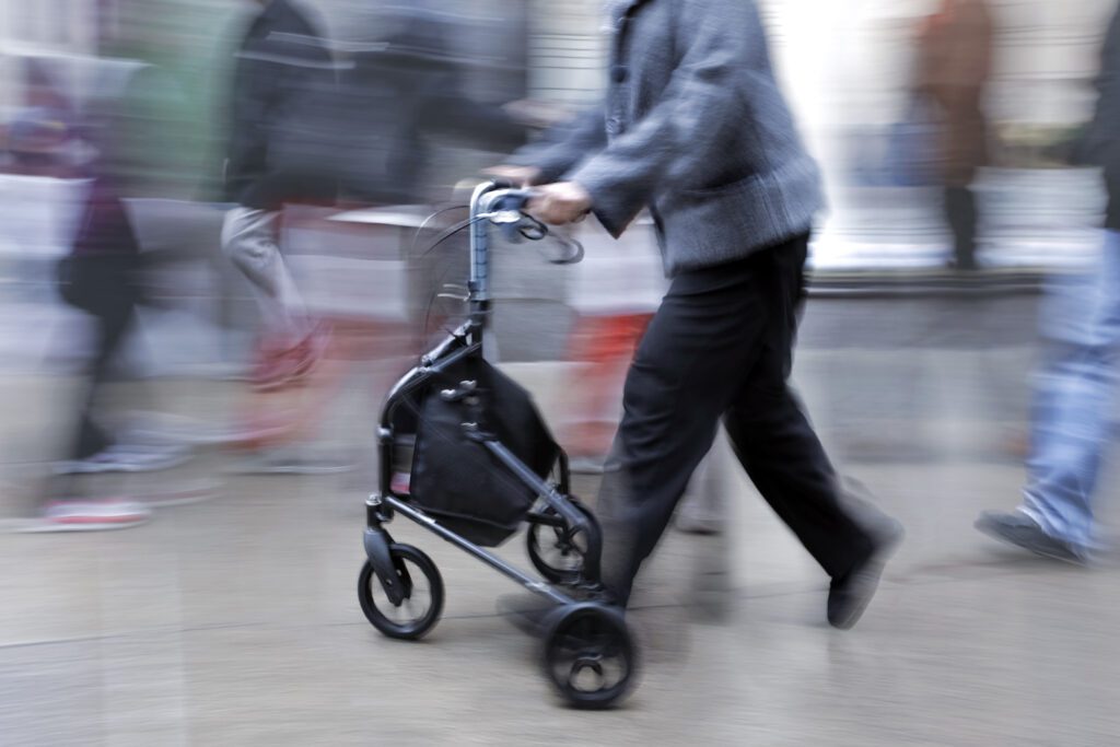 woman walking with a three-wheeled walker