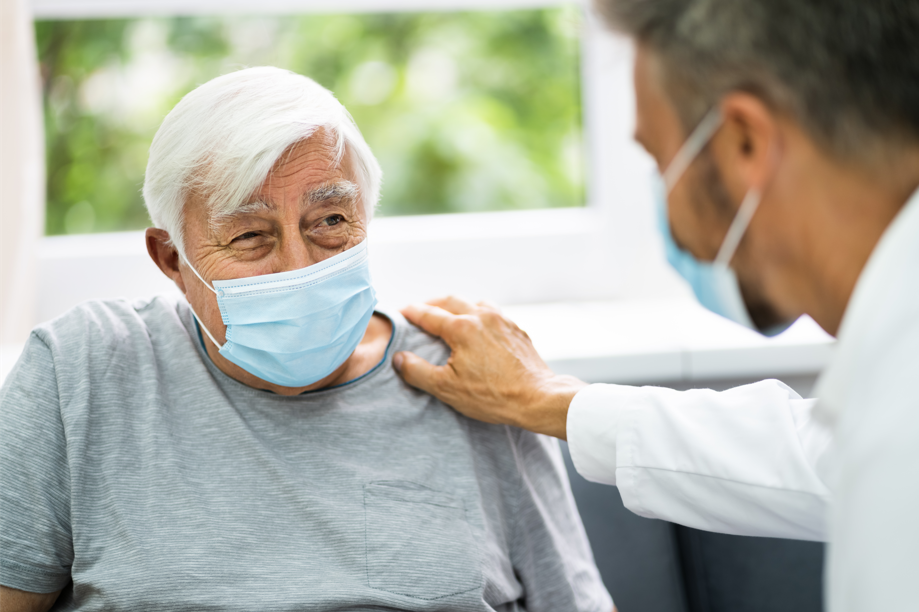 man in mask talking to doctor