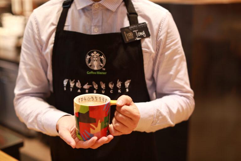 Person wearing Starbucks apron with ASL lettering 
