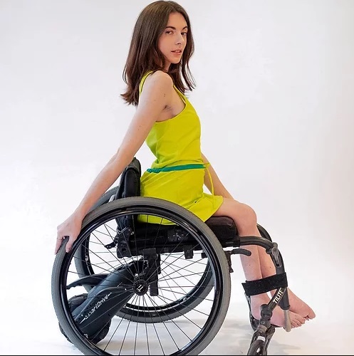 Model, in wheelchair, wearing Colette adaptive swimwear