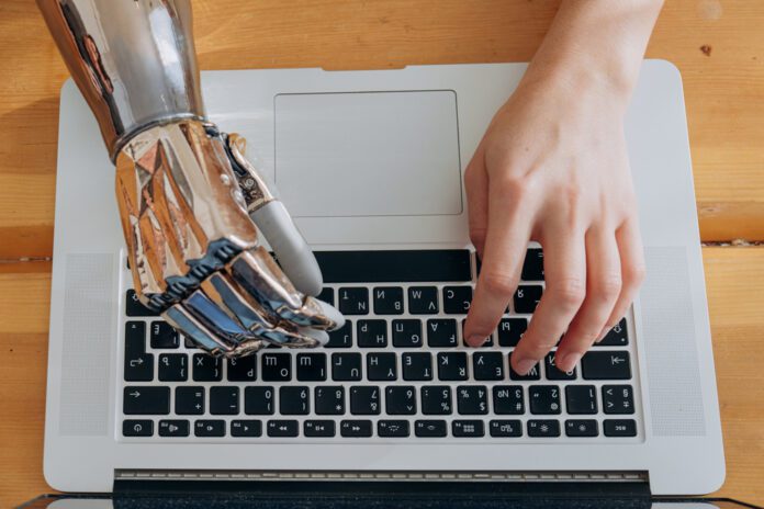 Typing hands, one prosthetic and one typical