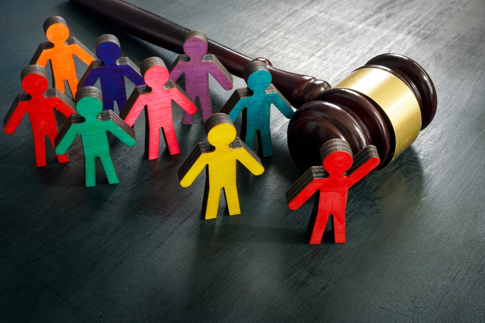 varying colored figurines representing diversity beside a gavel 