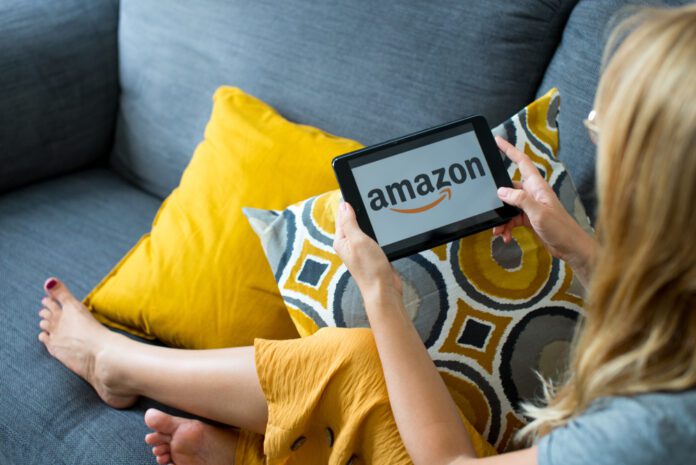 woman, sitting on couch, using Amazon app