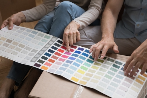 A couple picks out paint colors from a brochure.