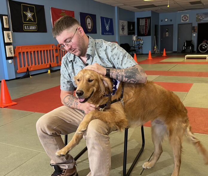 Purple Heart recipient and U.S Marine, Russel Anderson, pictured with his service dog provided by Paws of War