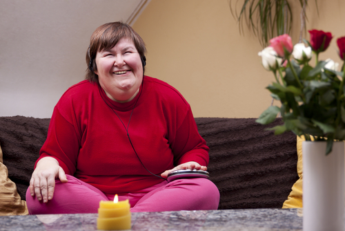 Women, with intellectual disabilities, listens to a meditation app using headphones.