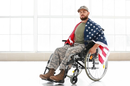 Veteran, in wheelchair with American flag, ponders how to prepare people with disabilities for Independence day fireworks