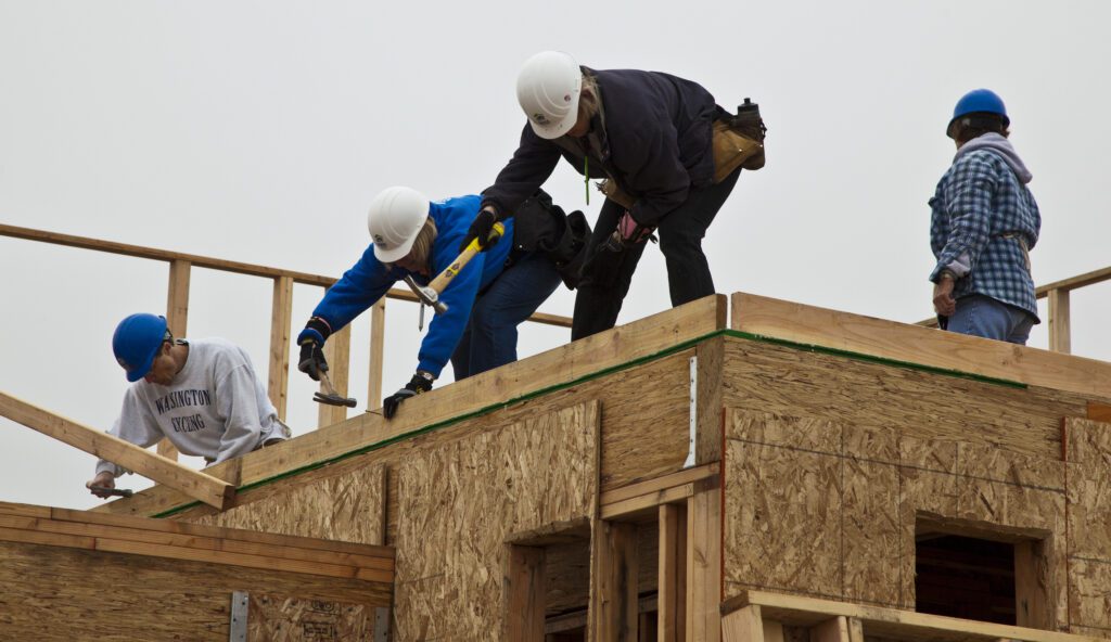 Volunteers help to build new homes for the poor with Habitat For Humanity