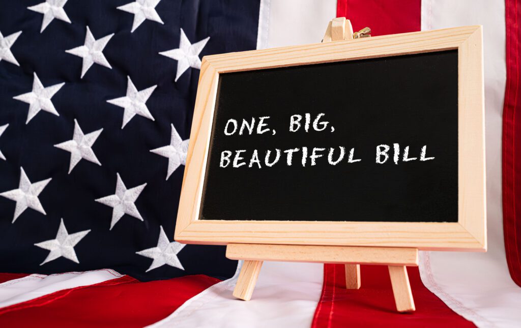 One Big Beautiful Bill Act chalkboard sign with American flag background, USA legislation budget concept