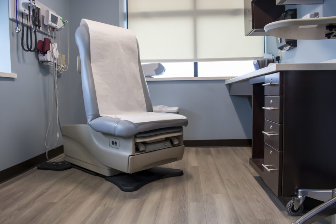 Patient room Exam Chair Treatment Table at a phycisan's office with wall of examining devices