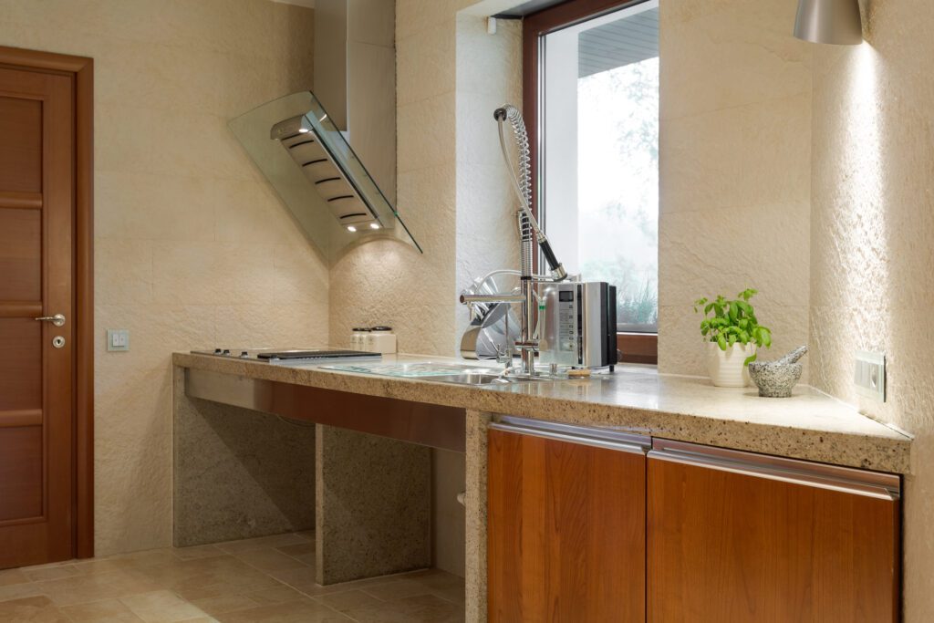 Accessible kitchen showing open space under stove and sink for wheelchair users.