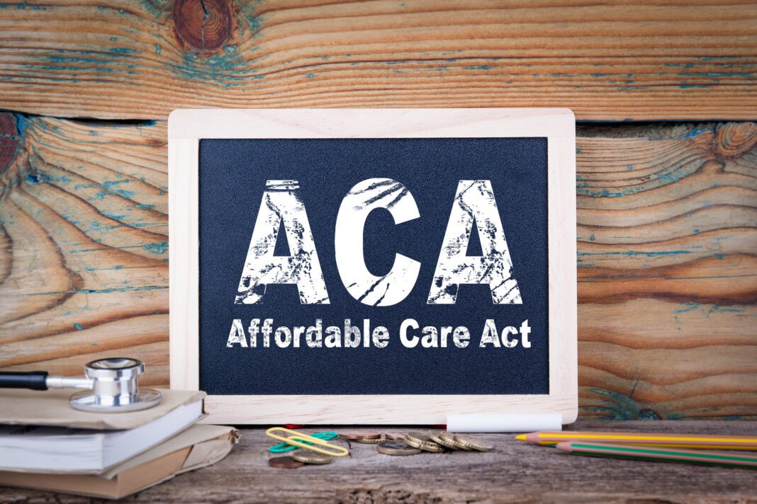 aca, affordable care act. Chalkboard on a wooden background