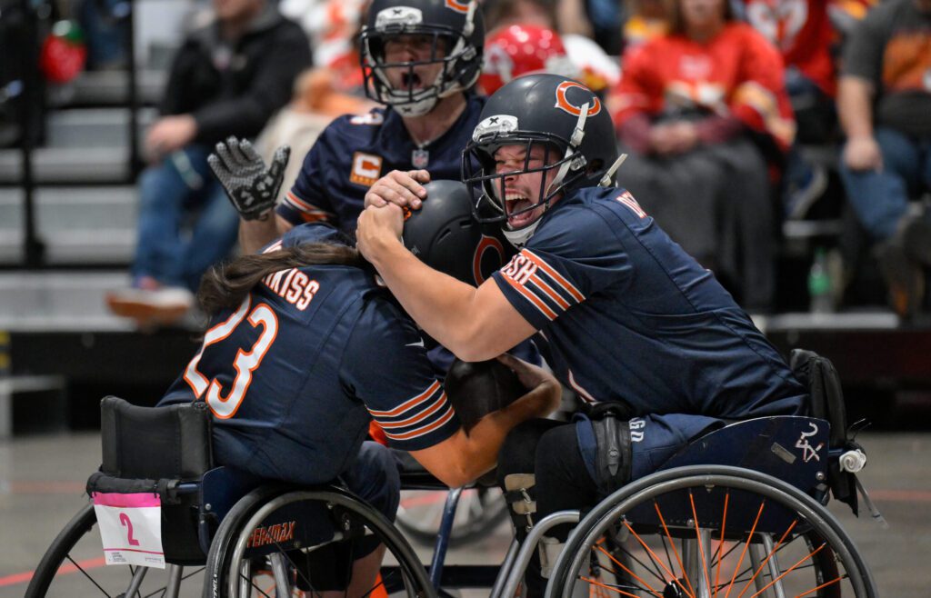 The Chicago Bears’ Gave Denbraber, left, hugs teammate Noah Hotchkiss (23) after Hotchkiss scored against the Kansas City Chiefs during the Wheelchair Football Championship, sponsored by Move United. The Chiefs defeated the Bears in overtime, 26-20.