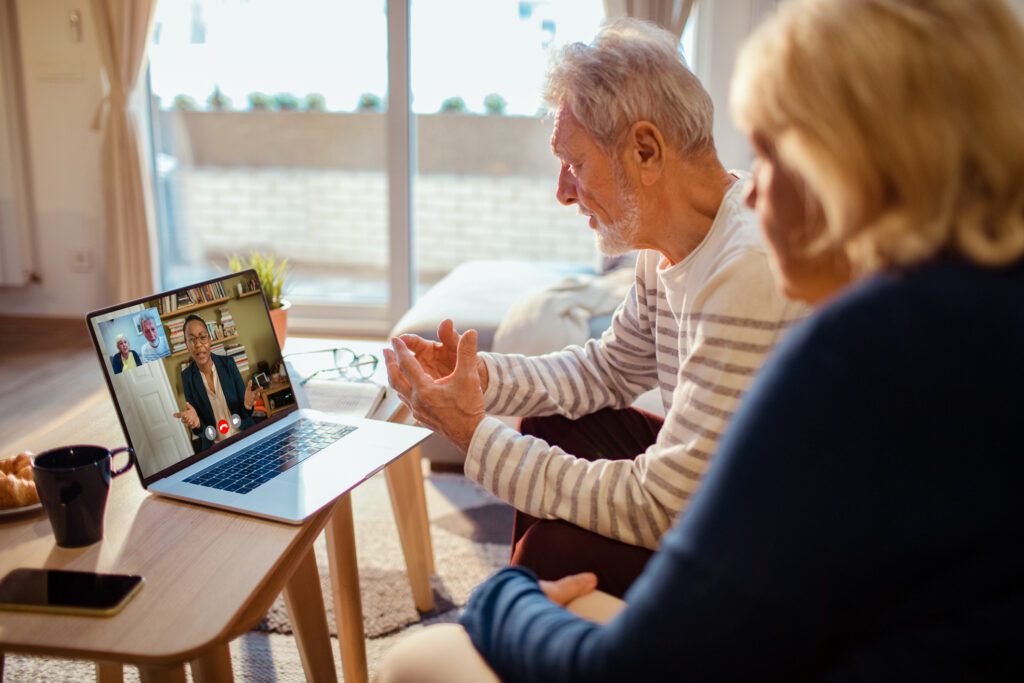 Close up of a senior couple talking to their counsellor over a video call