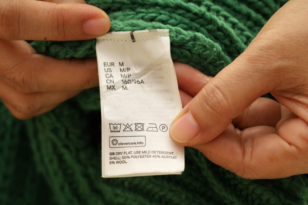 Washing instruction labels on a green sweater