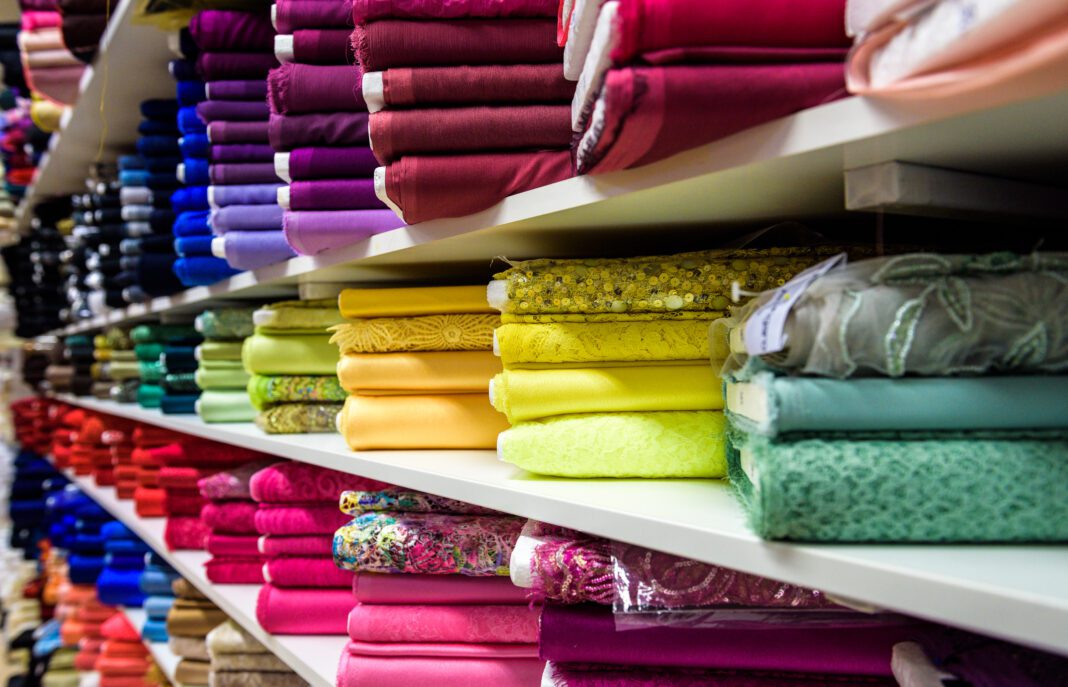 Rolls of fabric and textiles in a factory shop or store or bazar. Multi different colors and patterns on the market. Industrial fabrics.